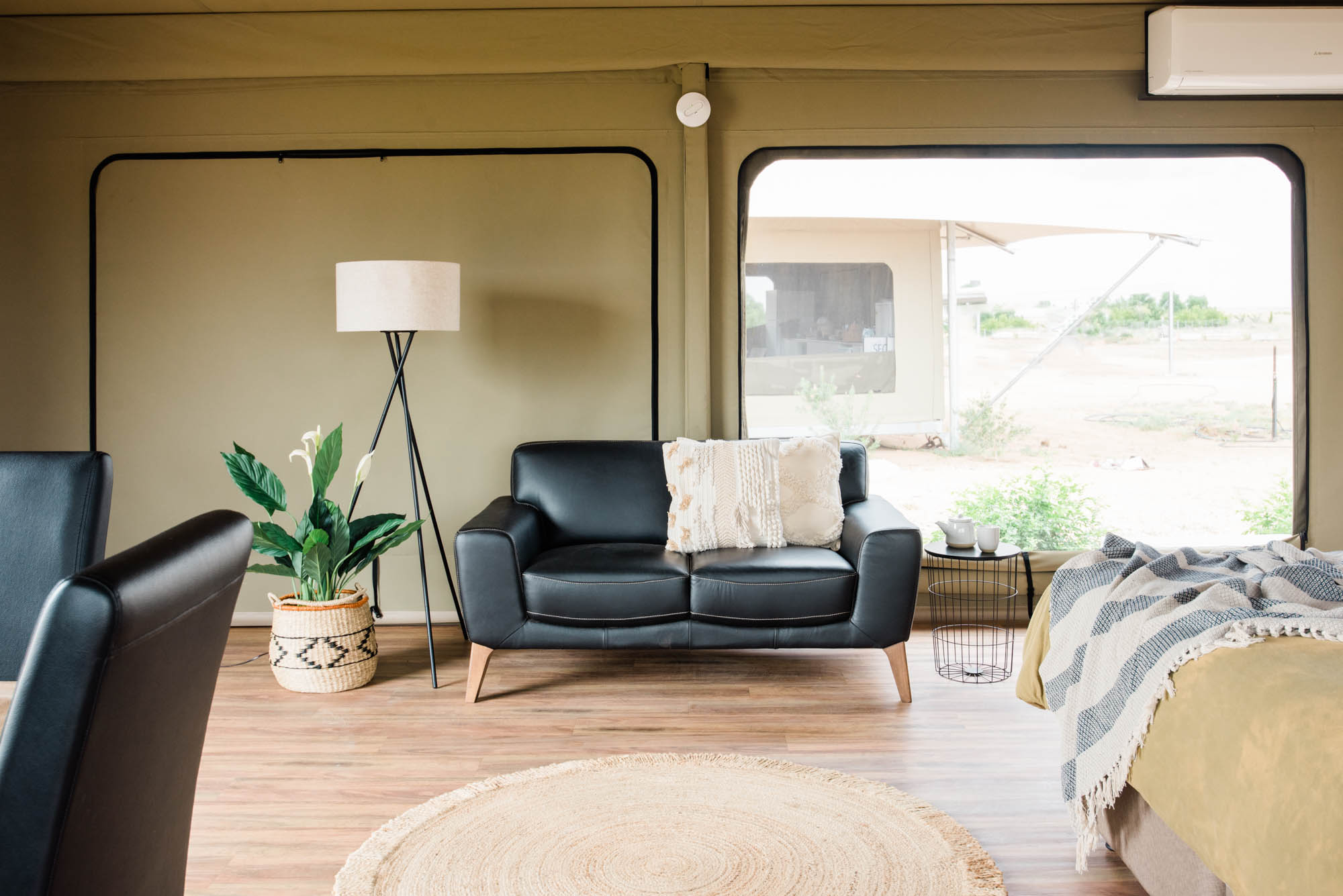 The beautiful black leather lounge inside a Mulga tent.