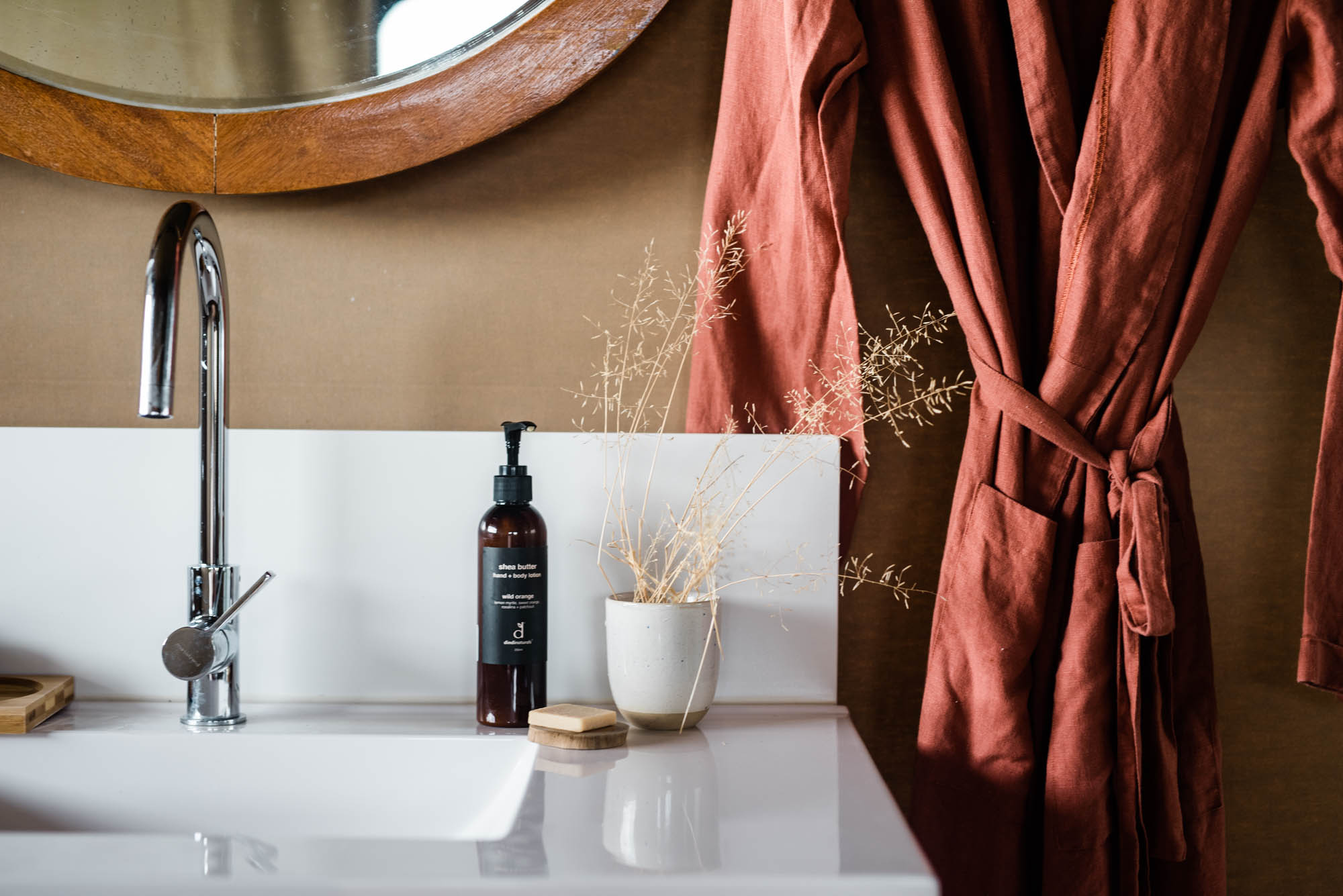 Bathroom sink and hanging bathrobe inside glamping tent at Mitchell Grass Retreat