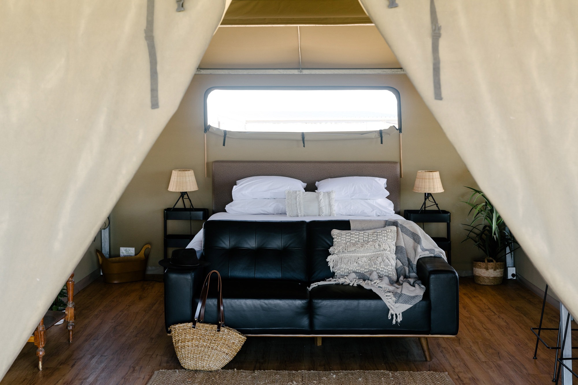 The black leather coach at the foot of the double bed inside the Gidyea Glamping Tent at Mitchell Grass Retreat Longreach.